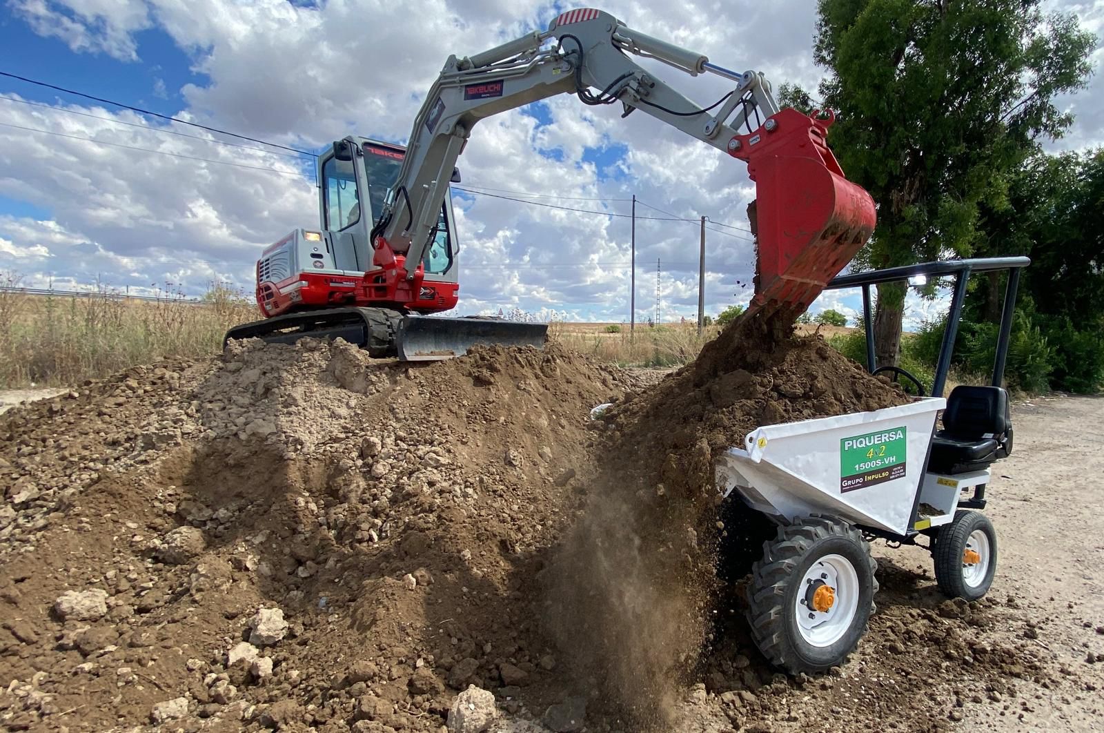 Miniexcavadora Takeuchi cargando dumper Piquersa en obra